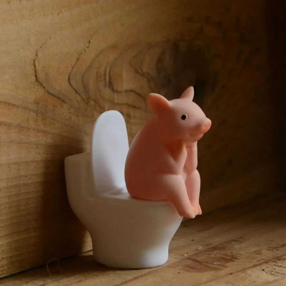 Figurine de cochon assise sur les toilettes