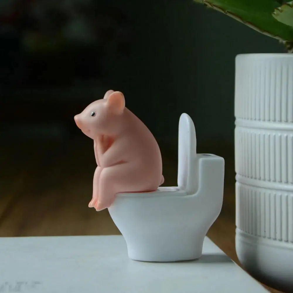 Figurine de cochon assise sur les toilettes